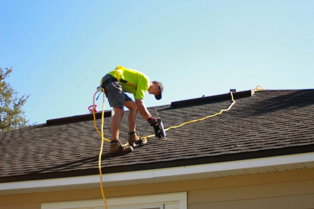 Roofer installing shingles on a residential roof