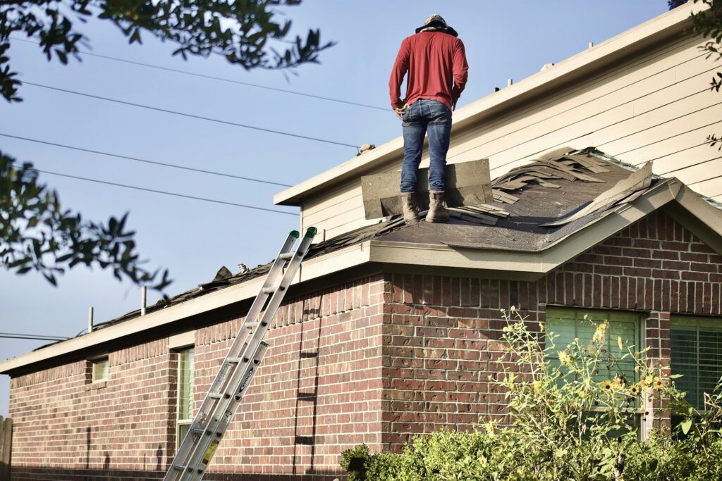 Roofer on the roof of a brick home